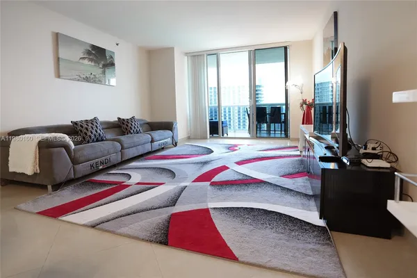 a living room with furniture and a floor to ceiling window