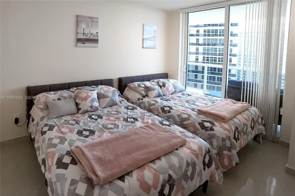 a bedroom with a bed next to a window