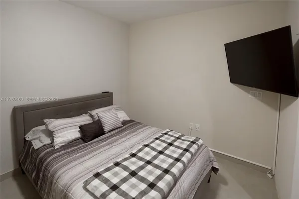a bedroom with a bed and a flat screen tv
