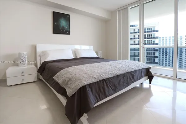 a bedroom with a large bed and a night stand