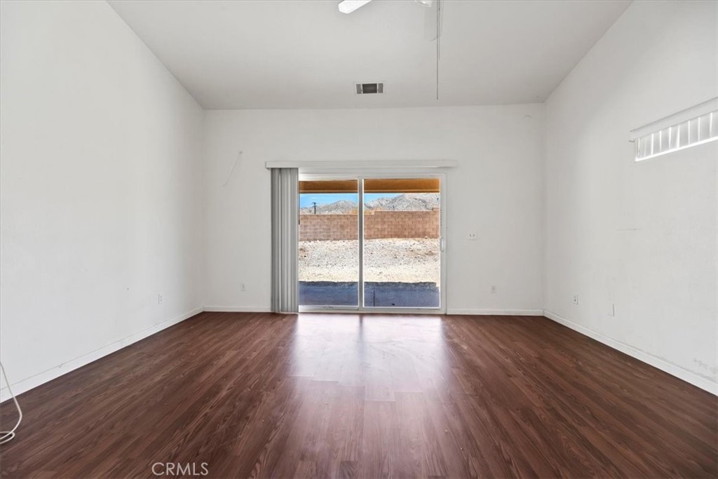 66034 Santa Rosa Road Desert Hot Springs, CA 92240 - Photo 35 of 54 an empty room with wooden floor and windows