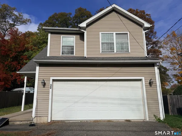 a view of a house with a yard and large garage