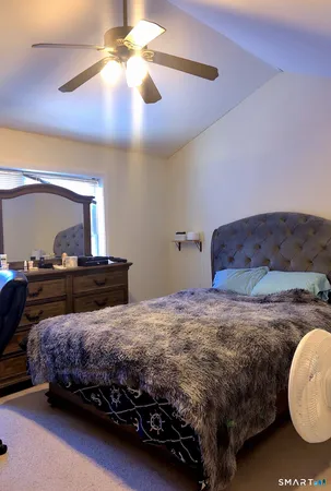 a bedroom with a bed and a chandelier fan