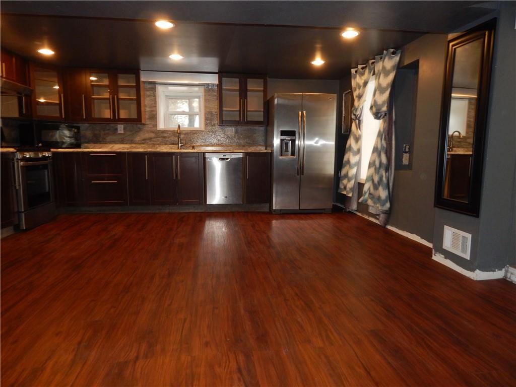 543 Oneida Valley Road Butler, PA 16001 - Photo 11 of 30 a kitchen with stainless steel appliances granite countertop a refrigerator a sink dishwasher a stove and white countertops with wooden floor