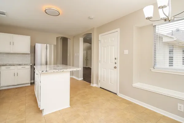 a room with kitchen island a sink cabinets and window