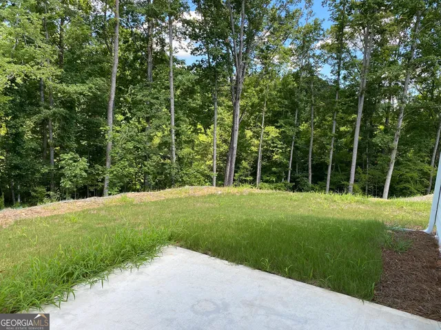 a view of a grassy field with trees in the background