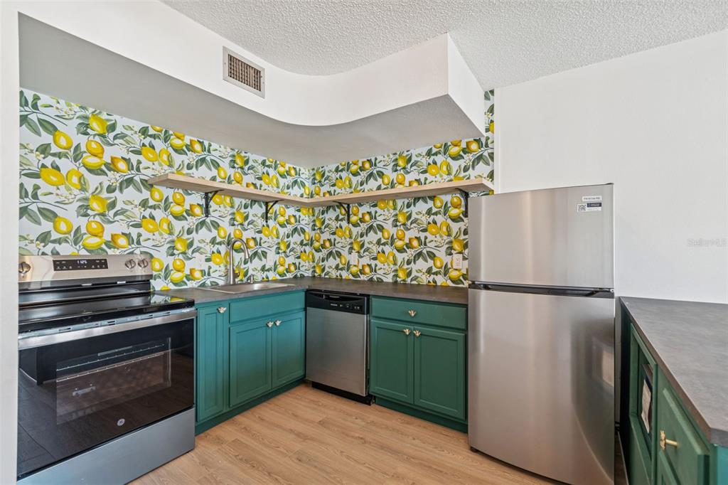 4511 South Oak Drive, Unit R32A Tampa, FL 33611 - Photo 11 of 27 a kitchen with granite countertop a refrigerator and a stove
