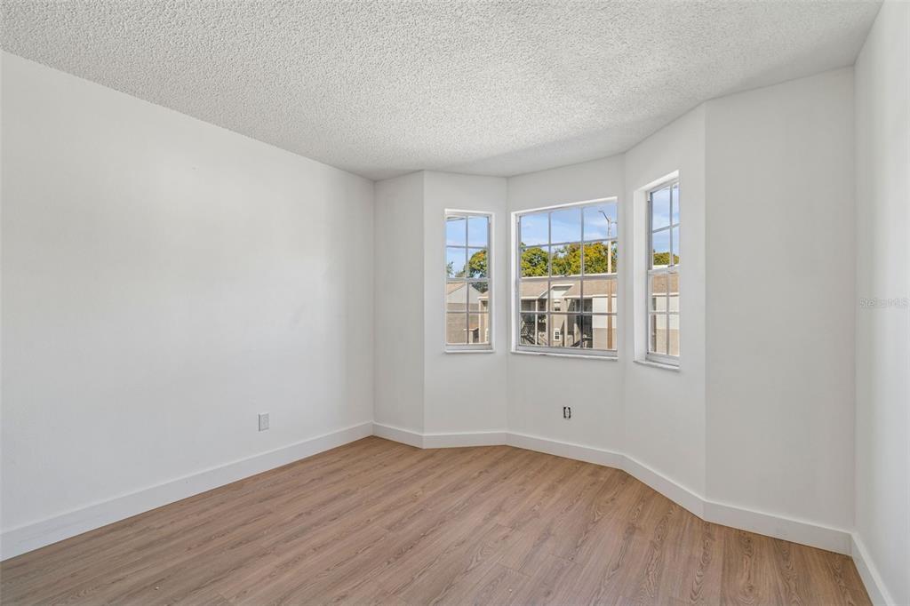 4511 South Oak Drive, Unit R32A Tampa, FL 33611 - Photo 14 of 27 a view of an empty room with wooden floor and a window