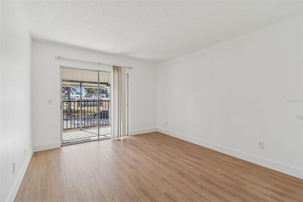 4511 South Oak Drive, Unit R32A Tampa, FL 33611 - Photo 18 of 27 wooden floor in an empty room with a window