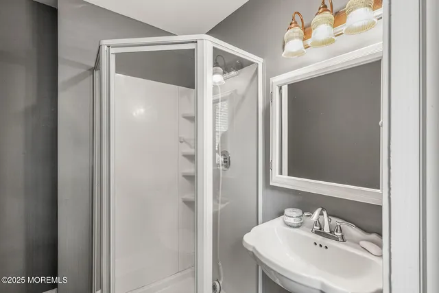 a bathroom with a sink mirror and shower