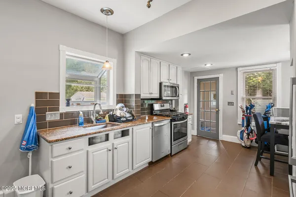 a kitchen with sink a stove and cabinets