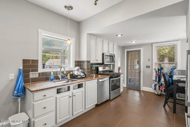a kitchen with sink a stove and cabinets