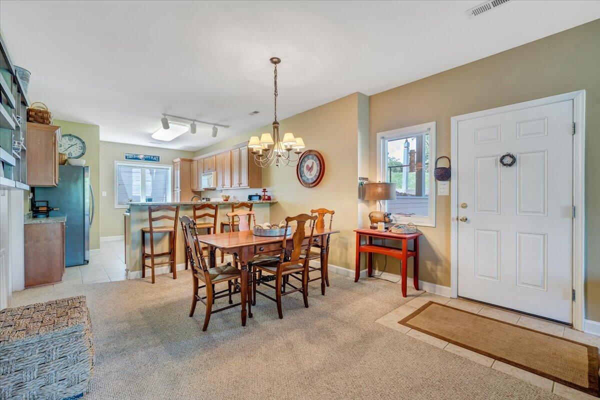 1209 Mariners Way, Unit 69 Huddleston, VA 24104 - Photo 11 of 72 a view of a dining room and livingroom with furniture wooden floor a rug a painting and a chandelier