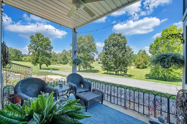 a view of a porch with furniture and floor to ceiling window