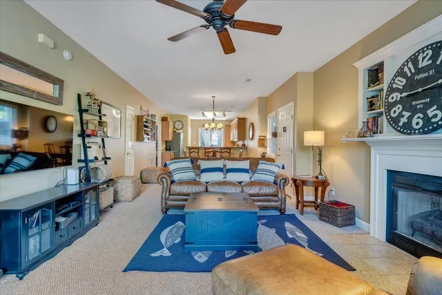 a living room with furniture kitchen view and a window