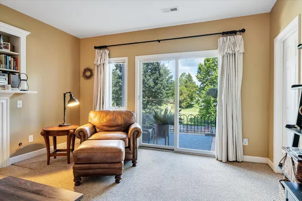 a view of a dining room and livingroom with furniture wooden floor a rug a painting and a chandelier