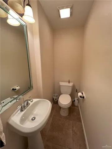 a bathroom with a sink and mirror with toilet