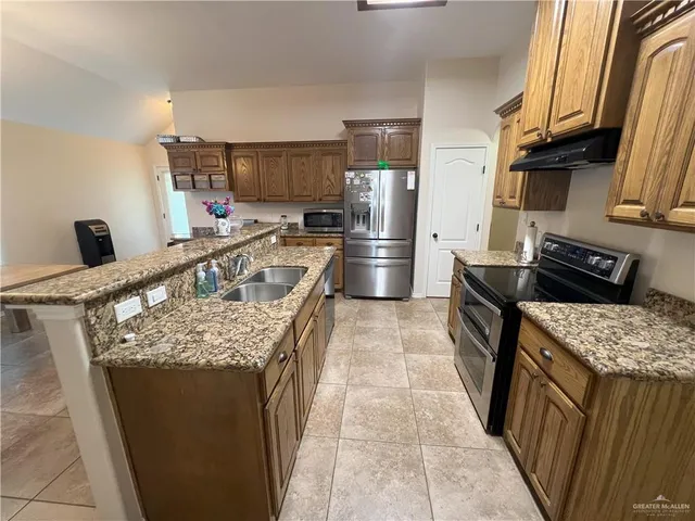 a kitchen with stainless steel appliances granite countertop a sink stove and refrigerator