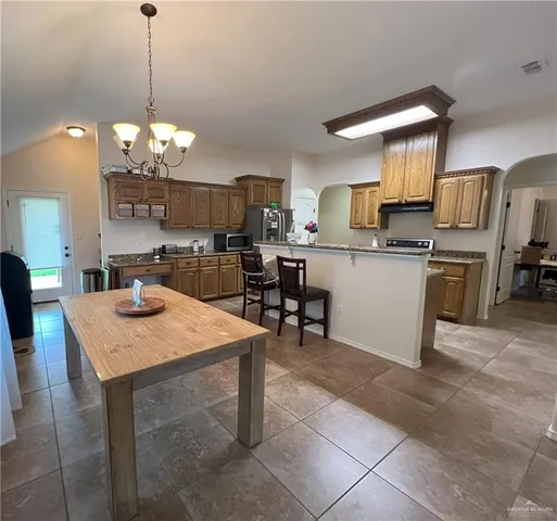 a kitchen with kitchen island a cabinets counter and dining table