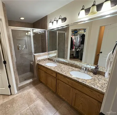 a bathroom with a granite countertop sink mirror and shower