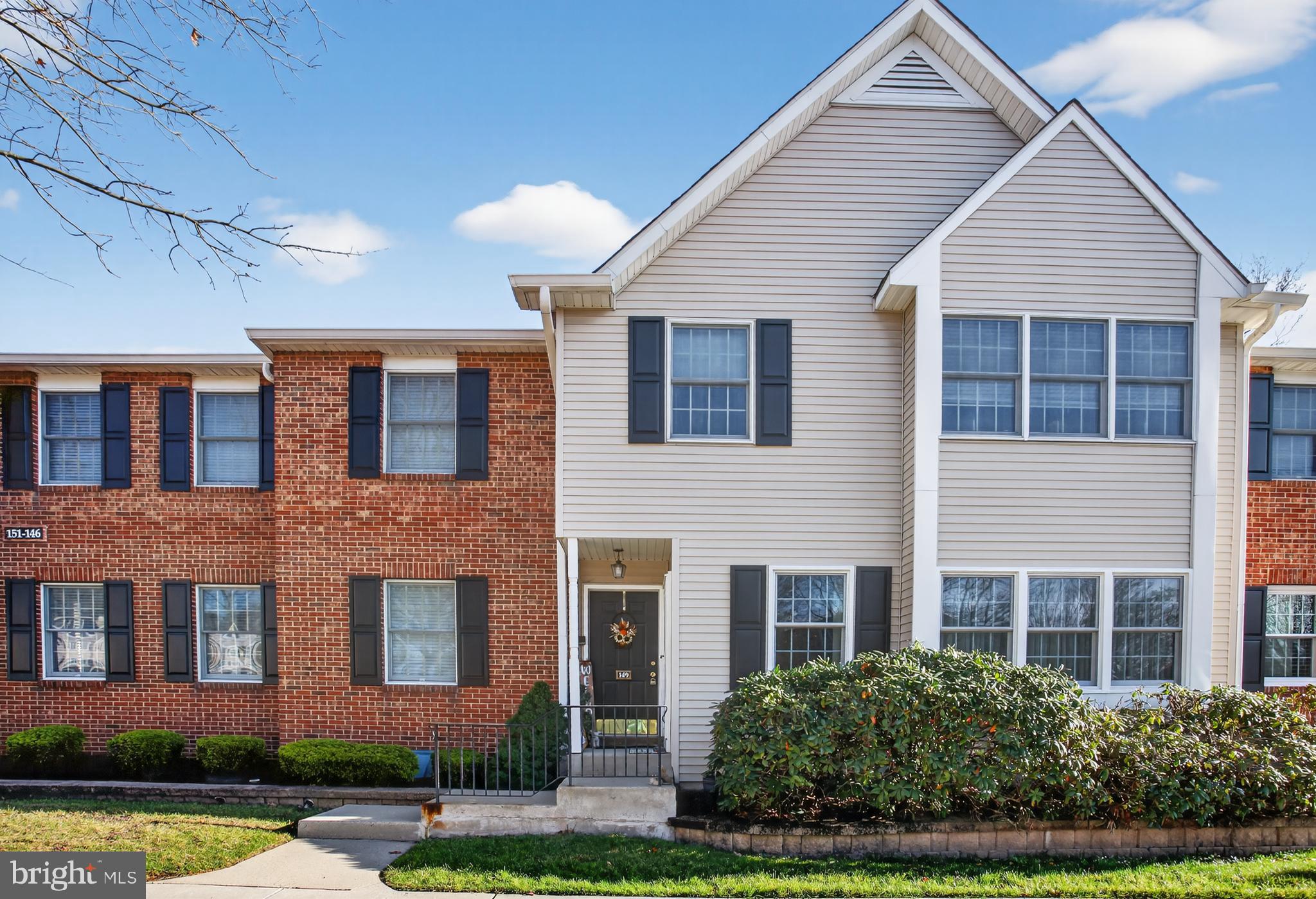 a front view of a house with a yard and potted plants