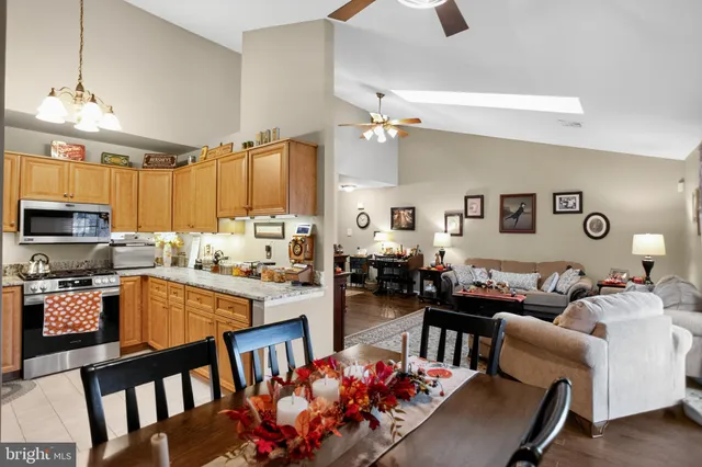 a living room with kitchen island furniture a flat screen tv and kitchen view