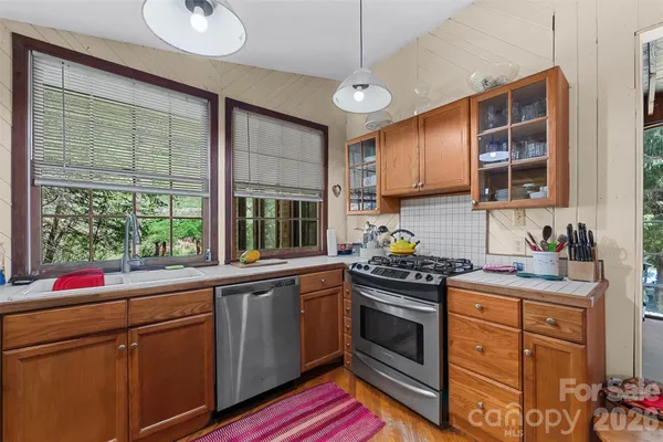 a kitchen with stainless steel appliances granite countertop a sink stove and cabinets