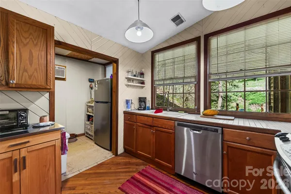a kitchen with stainless steel appliances granite countertop a sink and wooden cabinets