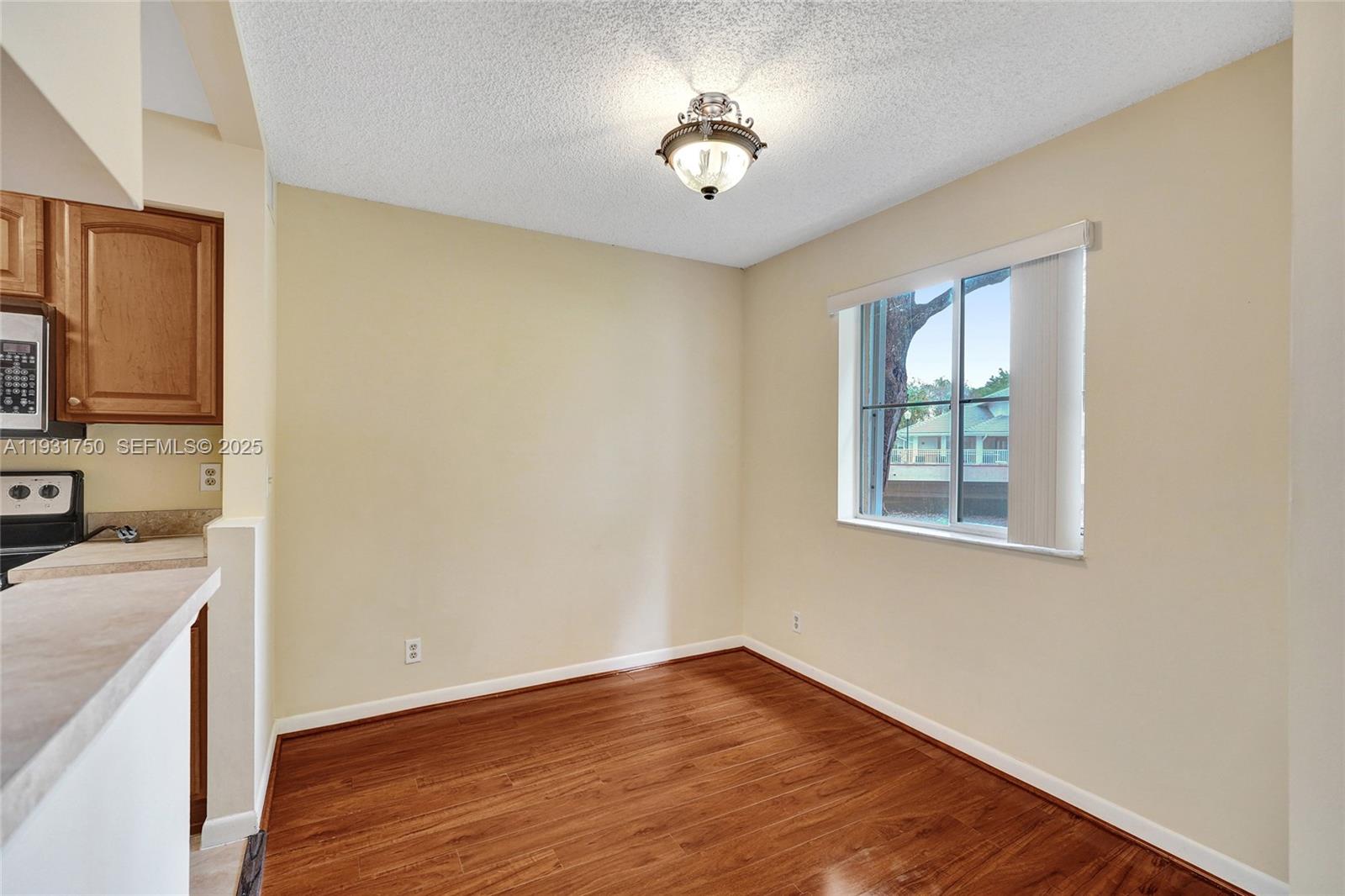9833 Westview Drive, Unit 819 Coral Springs, FL 33076 - Photo 13 of 47 a view of a kitchen with a stove wooden floor and a window