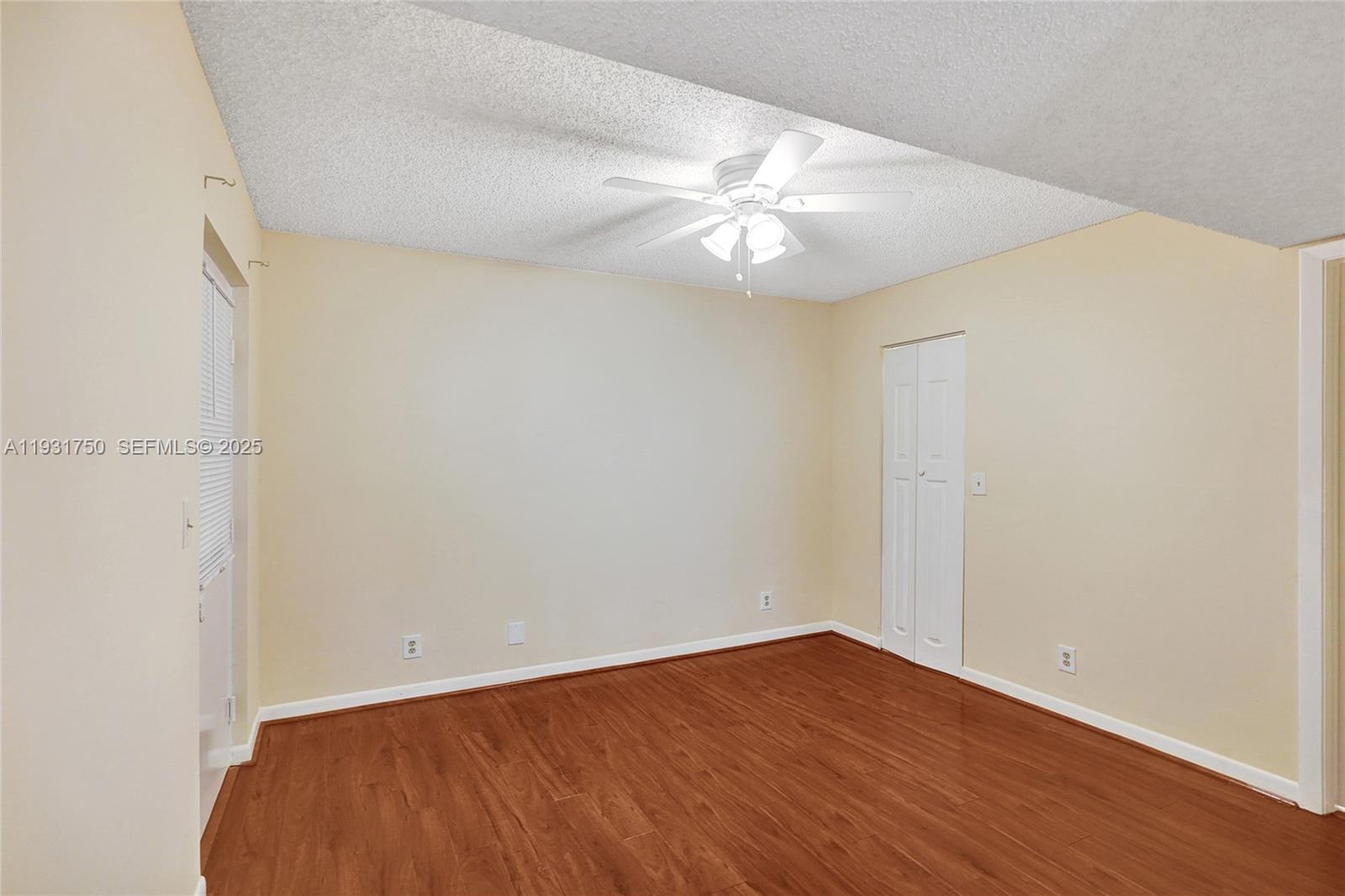 9833 Westview Drive, Unit 819 Coral Springs, FL 33076 - Photo 21 of 47 an empty room with wooden floor and fan