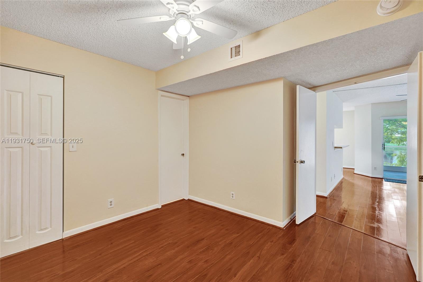 9833 Westview Drive, Unit 819 Coral Springs, FL 33076 - Photo 25 of 47 an empty room with wooden floor and windows