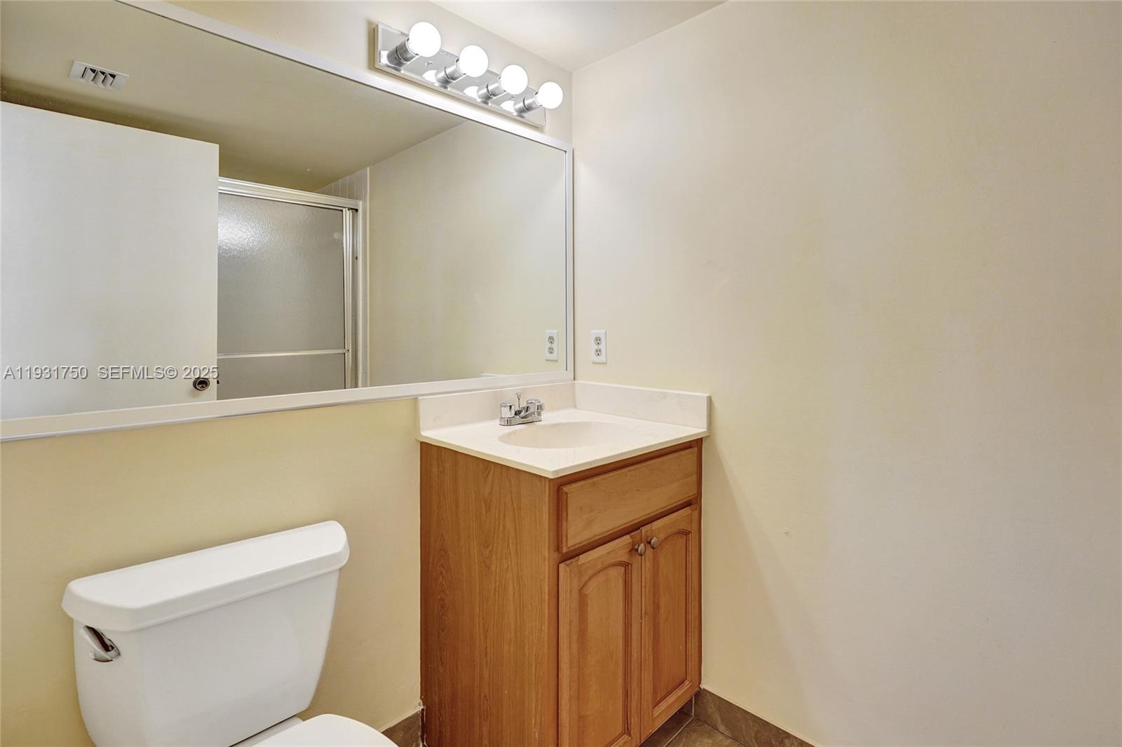 9833 Westview Drive, Unit 819 Coral Springs, FL 33076 - Photo 35 of 47 a bathroom with a sink mirror and toilet