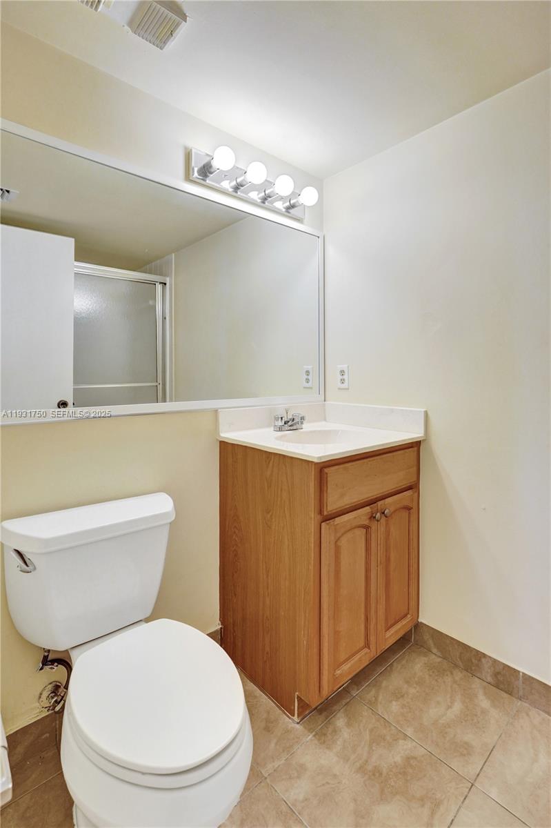 9833 Westview Drive, Unit 819 Coral Springs, FL 33076 - Photo 36 of 47 a bathroom with a toilet sink and mirror