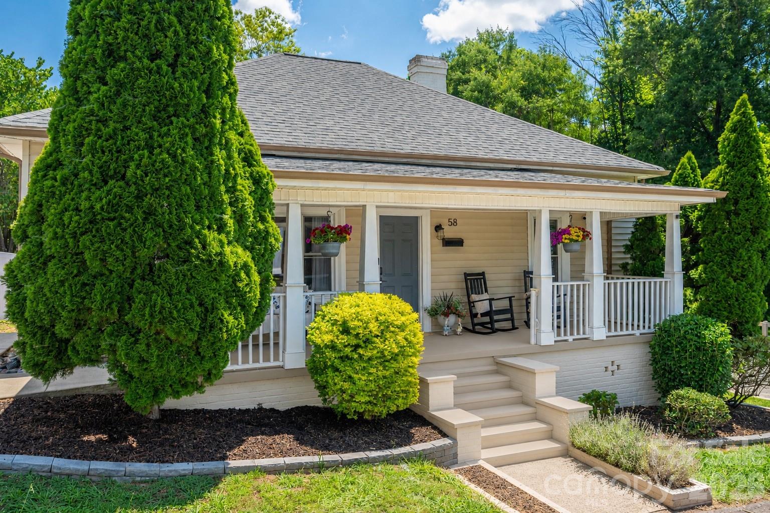 58 Fourth Street Cramerton, NC 28032 - Photo 1 of 44 a view of a white house with potted plants and a large tree