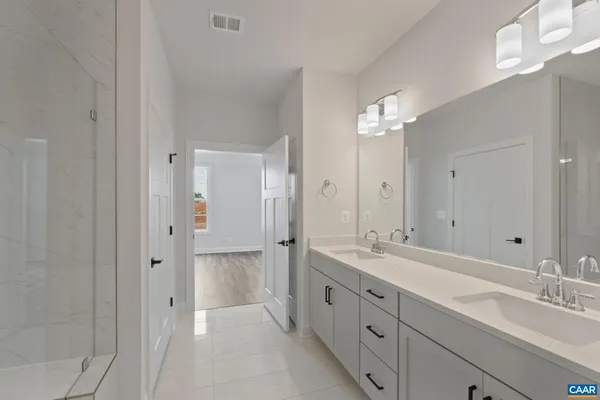 a spacious bathroom with a double vanity sink mirror and double