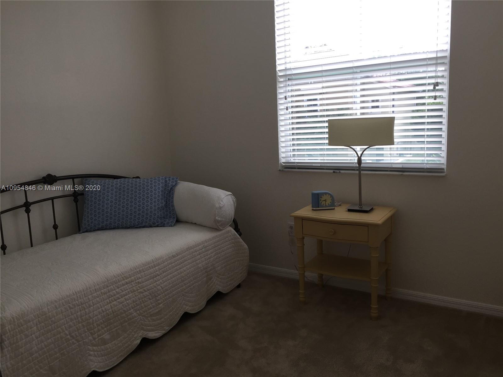 2851 Prospect Road, Unit 1306 Tamarac, FL 33309 - Photo 13 of 15 a bedroom with a bed and a table