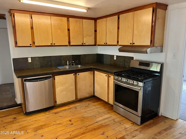 a kitchen with stainless steel appliances granite countertop a stove a sink and a microwave