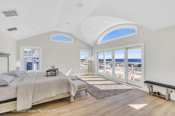 a bedroom with a bed and a large window with the outer view