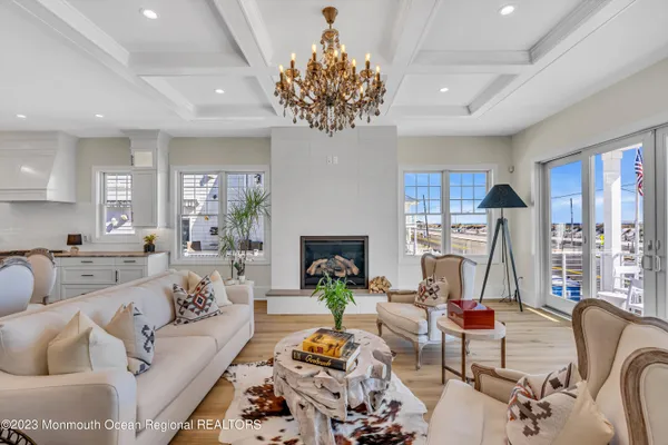 a living room with furniture a chandelier and a fireplace