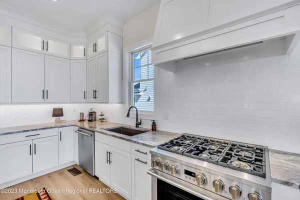 a kitchen with sink stove and cabinets