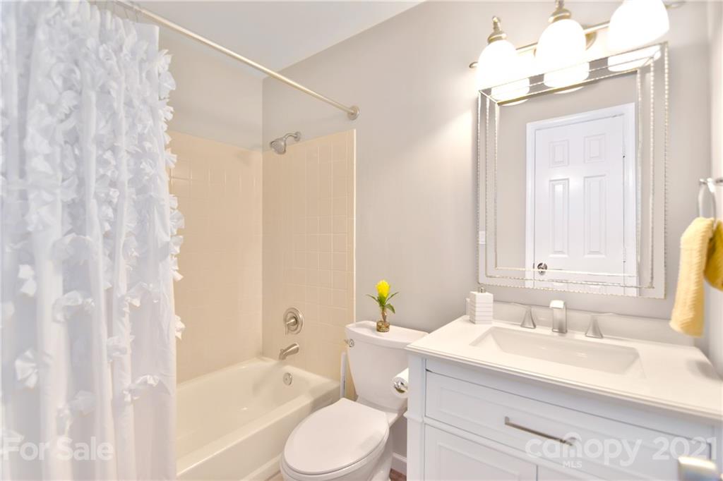 19831 Henderson Road, Unit A Cornelius, NC 28031 - Photo 11 of 15 a bathroom with a sink vanity granite toilet and shower
