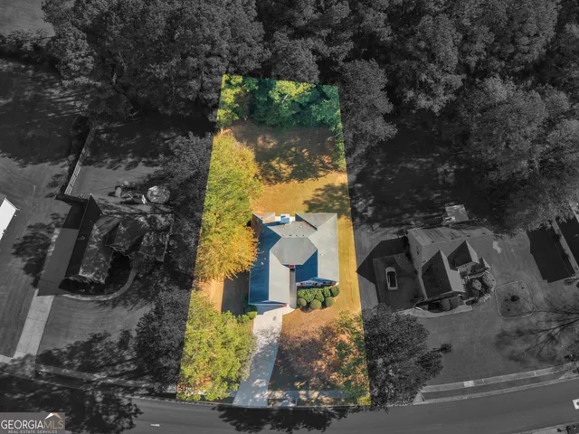 an aerial view of a house with a yard and large trees
