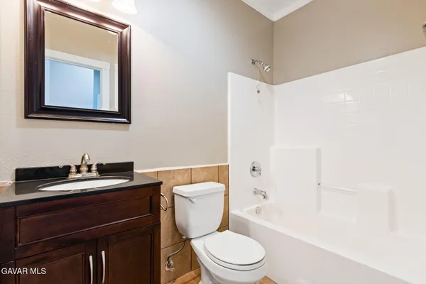 a bathroom with a toilet a sink a vanity and mirror