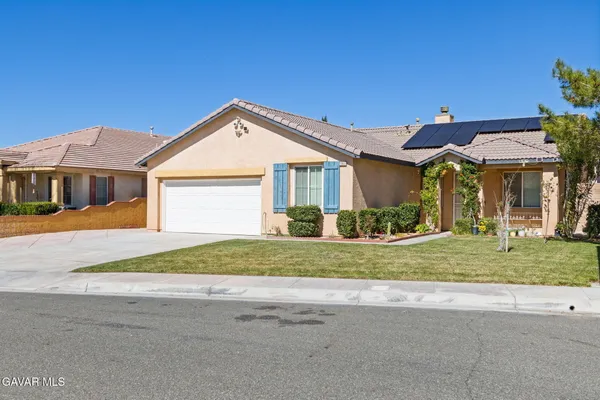 a front view of a house with a yard and potted plants