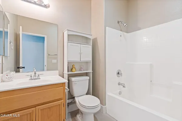 a bathroom with a granite countertop sink toilet mirror vanity and bathtub