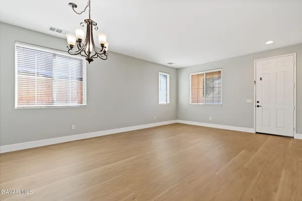 a view of empty room with wooden floor and windows