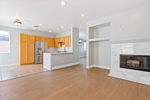 a view of a kitchen with a sink a fireplace and a window