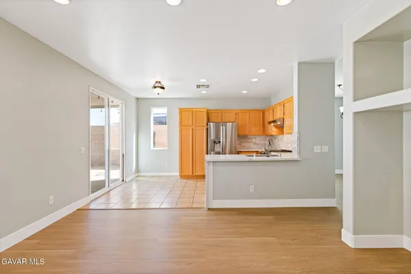 a view of a kitchen with wooden floor and a window