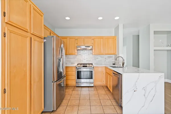 a kitchen with stainless steel appliances granite countertop a refrigerator and a sink