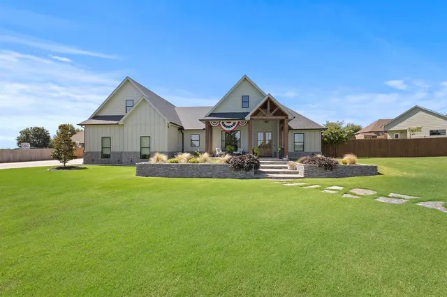 a front view of a house with yard and green space